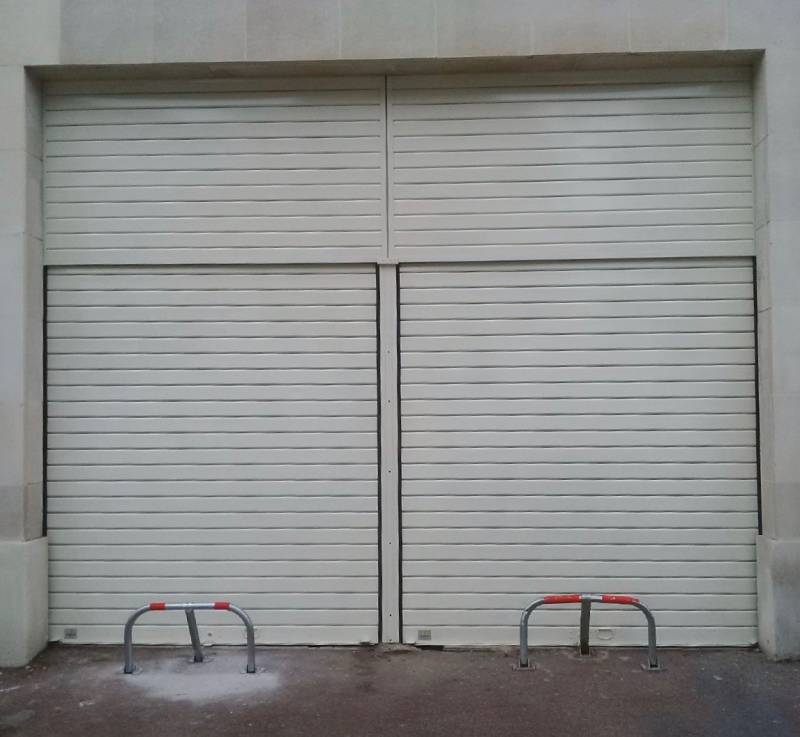 Fermeture complète de deux garages avec impostes fixes et arceaux de protection.